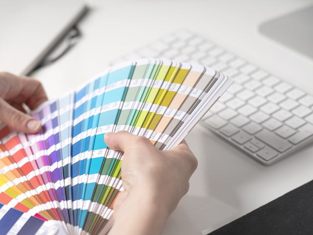 Fanning a colour swatch guide while checking a proof